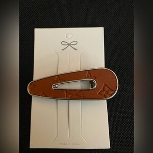 Fashionable light brown oval floral pattern hair clip.